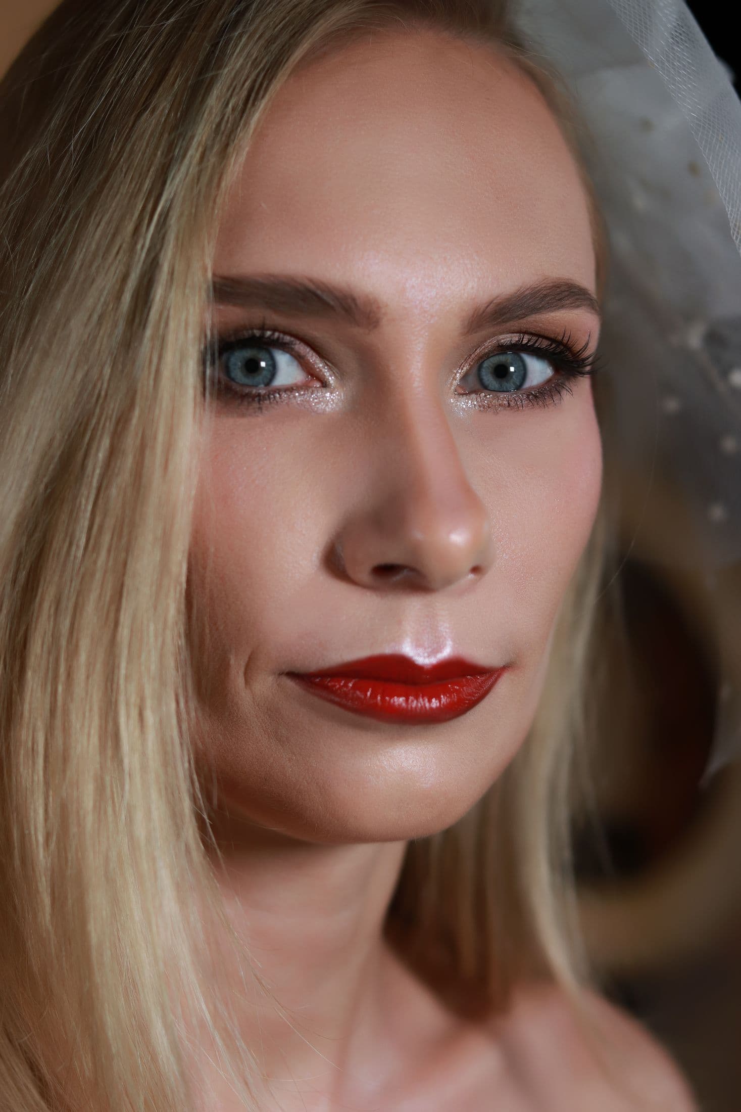 Close-up portrait with a defined red lip, soft eye makeup and blonde hair