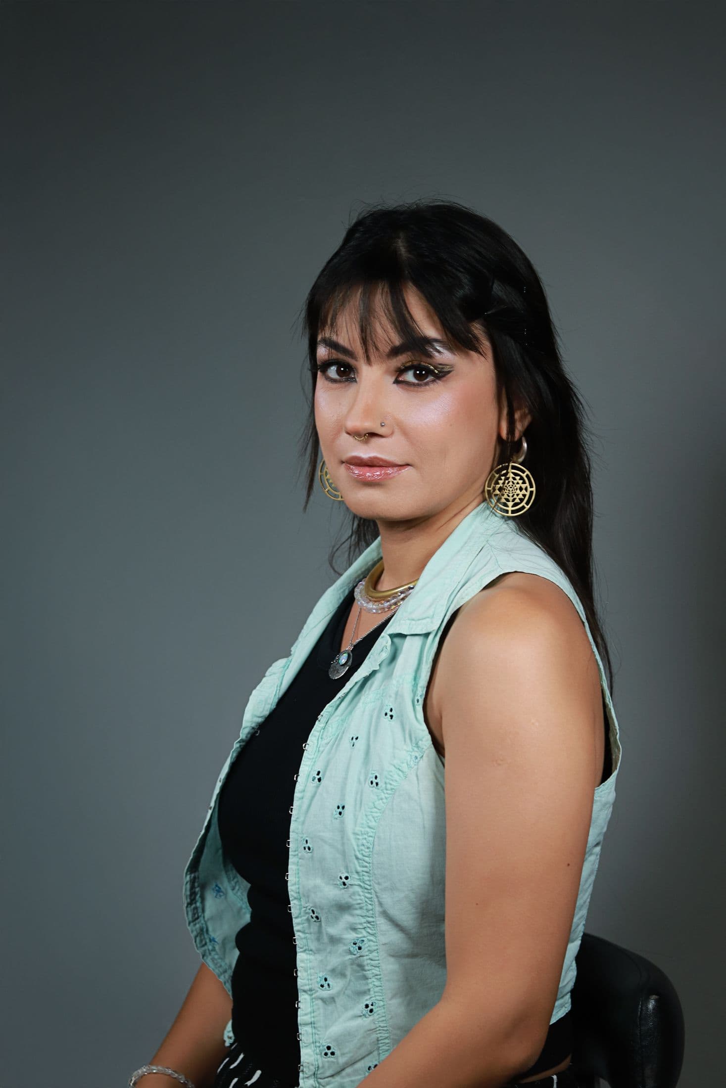Portrait with graphic black eyeliner, glowing skin and mint green styling
